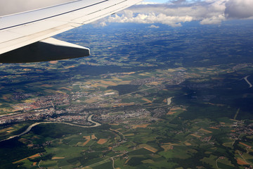 Widok miasta i pól z okna lecącego samolotu.