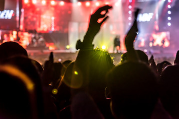 silhouettes of concert crowd in front of bright stage lights 