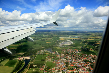 Widok miasta i pól z okna lecącego samolotu.