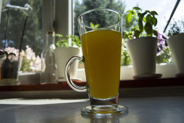 Orange drink in a glass on a countertop
