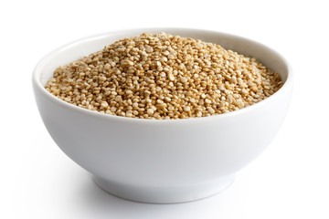 Quinoa seeds in white ceramic dish isolated on white.