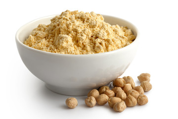 Chickpea flour in white ceramic dish isolated on white. Spilled chicklpeas.