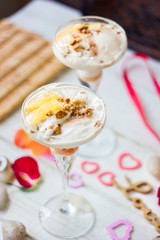 Ice cream dessert on table with hearts, ribbons and cloves.