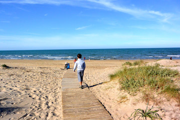 A boy is walking on Path to the sea