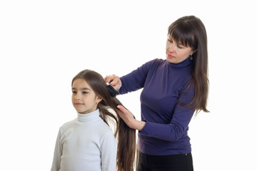 mother combing hair her little cute daughter