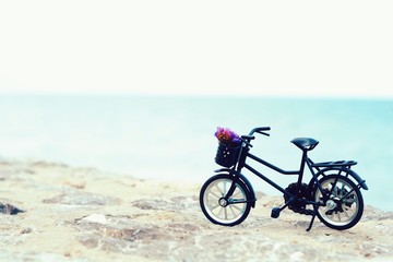 Fototapeta na wymiar Miniature bicycle on the beach background 