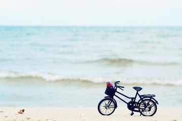 Fototapeta na wymiar Miniature bicycle on the beach background 
