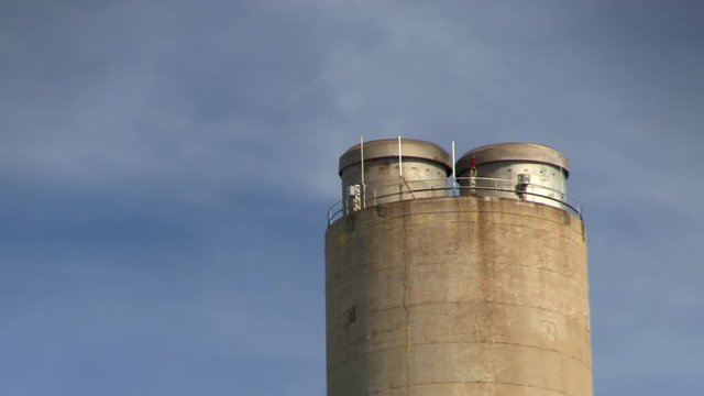Zoomed shot of power plant smoke stack with no belching smoke.
