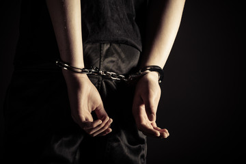Young man wearing handcuffs on his wrists - obrazy, fototapety, plakaty