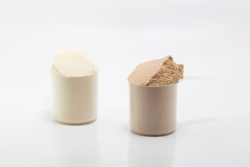 heap of isolate and chocolate protein powder with plastic spoon on white background