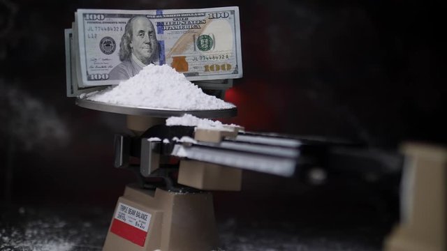 $100 BILLS DROP, AND STICK, INTO A PILE OF COCAINE.  IN SLOW MOTION.