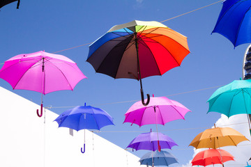 Fototapeta na wymiar Colorful umbrellas against the sky - a street decoration