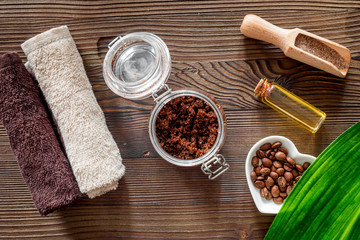 Composition of spa treatment. Coffee scrub, coffee salt and oil on wooden table background top view