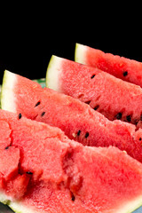 Slices of watermelons on the table with black background.