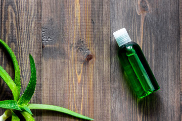 Obraz na płótnie Canvas Organic aloe vera cosmetics. Aloe vera leafs, glass of aloe vera juice on wooden table background top view copyspace
