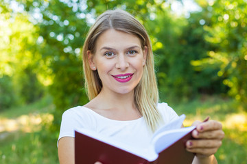 Fototapeta premium Beautiful female student holding a book