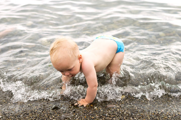 Little boy struggling with a wave on the sea coast