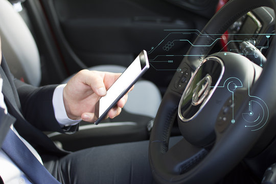 Close-up of a man's hand holding a smartphone. Businessman texting while sitting in a parking lot. Suit and tie man using a mobile phone. Hologram effect.