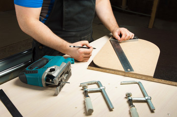 Male hands draw a pencil on the ruler