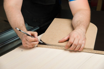 Male hands draw a pencil on the ruler