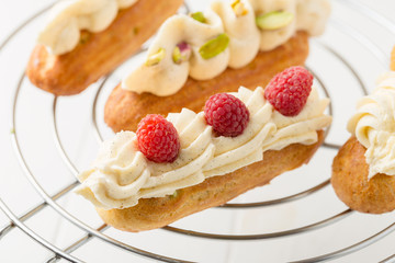 Eclair with vanilla cream and raspberries