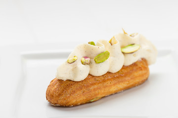 Eclair with vanilla cream and pistachio