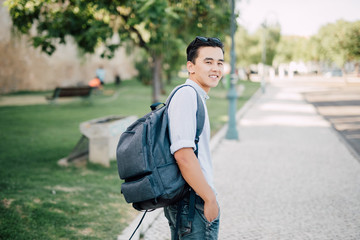 Portrait of a handsome asian young man smiling with bag