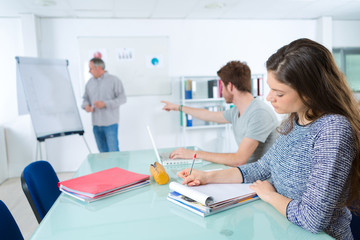 Obraz premium Class in progress, teacher stood by flip chart