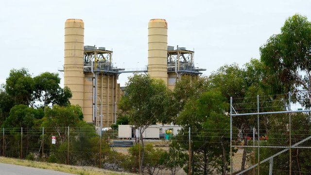 Gas fired electricity power station in remote industrial area, 4k handheld panning.