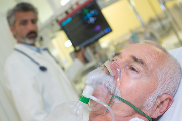 Doctor looking at patient wearing oxygen mask