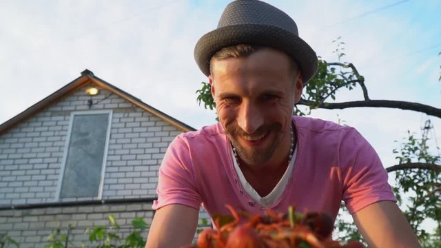 A man is serving a plate of boiled crayfish