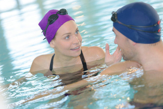 Two swimmers talking in pool