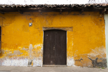 Window and wooden door in colonial house of La Antigua Guatemala, Central America.