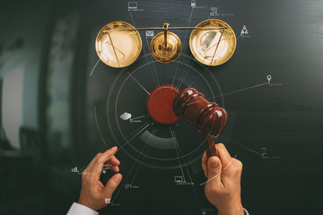 justice and law concept.Top view of Male judge hand in a courtroom with the gavel and brass scale on dark wood table with Vr diagram
