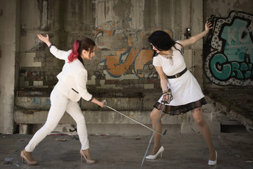 Two businesswomen are fighting at swords.