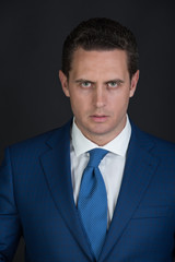 businessman posing in elegant blue jacket and tie