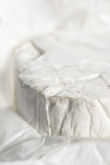 Close-up with Camembert cheese on white  craft paper