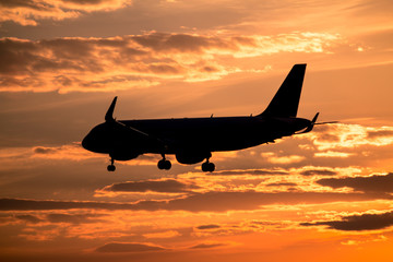 Airplane landing at sunset