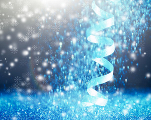 Shiny blue streamer and glitter on dark background