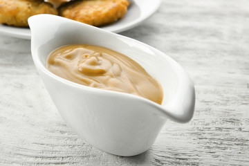Sauce boat with turkey gravy on wooden table