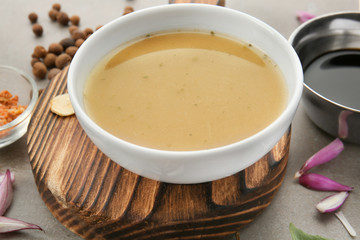 Bowl with turkey gravy and spices on grey table