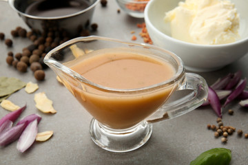 Sauce boat with turkey gravy and spices on table