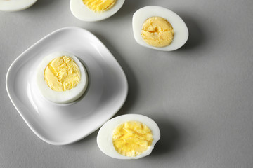 Hard boiled eggs and holder on grey background. Nutrition concept