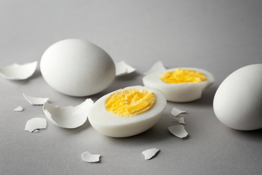 Hard boiled eggs and shell on grey background. Nutrition concept