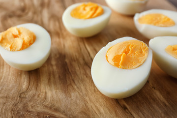 Sliced hard boiled eggs on wooden surface, closeup. Nutrition concept