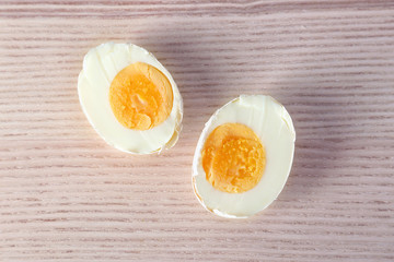 Sliced hard boiled egg in shell on wooden surface. Nutrition concept
