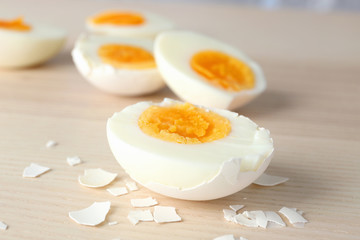 Sliced hard boiled eggs in shell on wooden surface. Nutrition concept