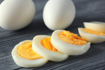 Sliced hard boiled eggs on wooden background. Nutrition concept