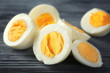 Sliced hard boiled eggs on wooden background. Nutrition concept