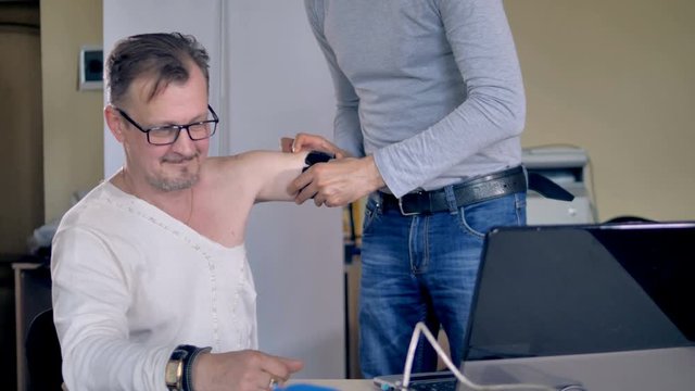 Setting bionic bracelet on man's amputated arm.